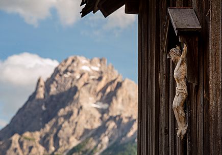 Crucifix with Croda Rossa or Cima Dieci on background,Sesto, dolomites, Italy