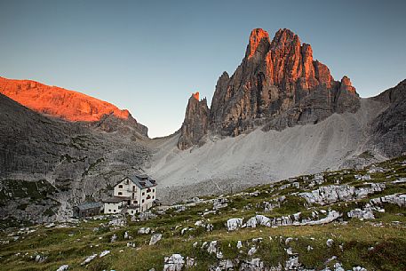 The alpine hut of Zsigmondy-Comici with the Croda dei Toni on background lit by sunset