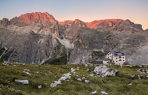 The alpine refuge Zsigmondy-Comici with Cima undici behind illuminated at sunset