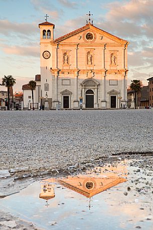 The Cathedral of Palmanova reflected on a puddle at sunset, Italy