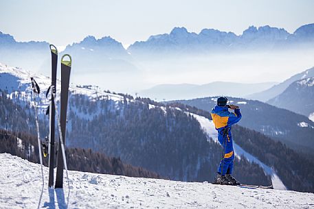 The skier is photographing the Comelico Dolomites from Elmo Mount, Sesto, dolomites, Italy