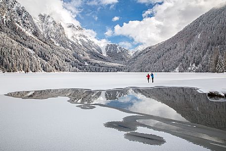 Cross country skiers admire the majestic winter landscape of Anterselva lake, Pusteria Valley, Italy