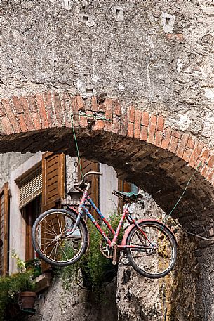 Bicycle hanging along the narrow streets of the medieval village of Malcesine on Lake Garda,Italy