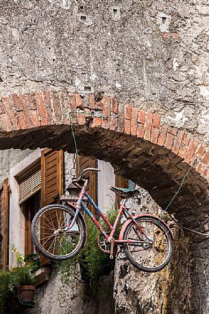 Bicycle hanging along the narrow streets of the medieval village of Malcesine on Lake Garda,Italy Bicycle hanging along the narrow streets of the medieval village of Malcesine on Lake Garda,Italy