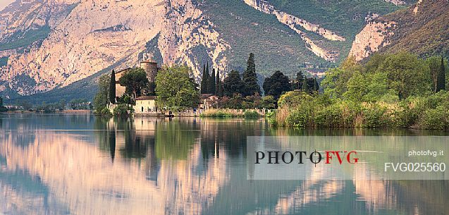 The Toblino Castle seen from the north shore reflects on the waters of the homonymous lake, Valley of Lakes, Trentino, Italy
