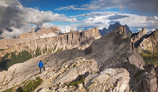 Hiker admires the panoramic view on the Dolomites from Nuvolau, Dolomites, Cortina D'Ampezzo, Italy