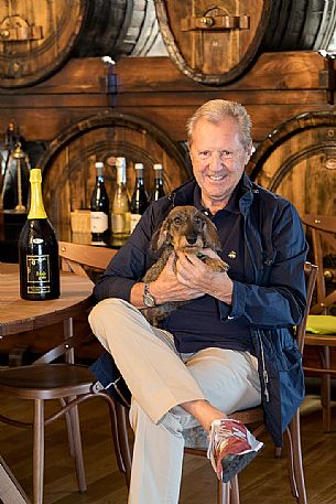 Manlio Collavini of the wine-growing company Eugenio Collavini with his dog, symbol of the cellar, Corno di Rosazzo, Friuli Venezia Giulia, Italy