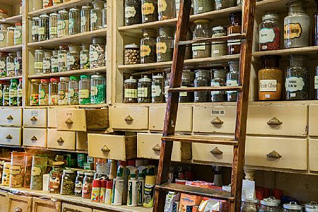 The shelves of the historic Toso grocery store, born in 1906, are high up to the ceiling and on their glass containers all kinds of spices are offered, even the stairs have not changed for more than a century, Trieste, Friuli Venezia Giulia, Italy The shelves of the historic Toso grocery store, born in 1906, are high up to the ceiling and on their glass containers all kinds of spices are offered, even the stairs have not changed for more than a century, Trieste, Friuli Venezia Giulia, Italy