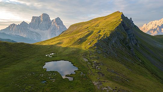 Pelmo Mount, Baste lake and the meadows of Mondeval during a summer morning, Dolomites, Italy Pelmo Mount, Baste lake and the meadows of Mondeval during a summer morning, Dolomites, Italy
