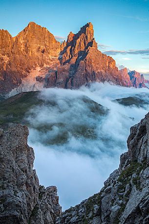 The northern chain of the Pale di San Martino with the Cimon della Pala over a cloud of clouds photographed from the top of the path of Cristo Pensante, Dolomites, San Martino di Castrozza, Italy