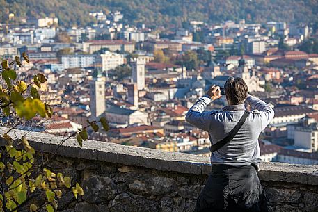 Tourist photographs the city of Trento from Doss Trento, Trento, Trentino Alto Adige, Italy

