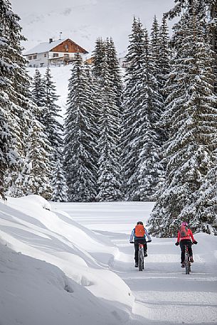 Two bikers along the path leading to the Nemes refuge in the backgroud, Sesto, Pusteria valley, Trentino Alto Adige, Italy, Europe Two bikers along the path leading to the Nemes refuge in the backgroud, Sesto, Pusteria valley, Trentino Alto Adige, Italy, Europe