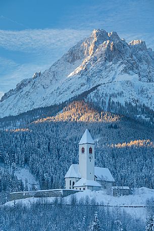 The church of the village of Versciaco after an intense snowfall, in the background the Rocca dei Baranci peak illuminated at dawn, Innichen, dolomites, Pusteria valley, Trentino Alto Adige, Italy, Europe The church of the village of Versciaco after an intense snowfall, in the background the Rocca dei Baranci peak illuminated at dawn, Innichen, dolomites, Pusteria valley, Trentino Alto Adige, Italy, Europe