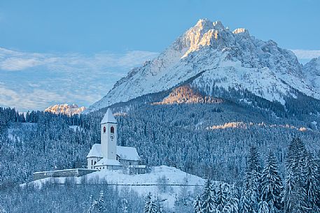The church of the village of Versciaco after an intense snowfall, in the background the Rocca dei Baranci peak illuminated at dawn, Innichen, dolomites, Pusteria valley, Trentino Alto Adige, Italy, Europe The church of the village of Versciaco after an intense snowfall, in the background the Rocca dei Baranci peak illuminated at dawn, Innichen, dolomites, Pusteria valley, Trentino Alto Adige, Italy, Europe