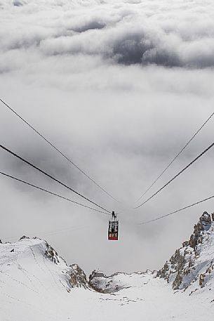 The cableway to the Lagazuoi mount adn refuge emerges from the sea of clouds, Cortina d'Ampezzo, dolomites, Veneto, Italy, Europe