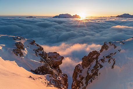 The sun sets behind the Marmolada peak over a sea of clouds, Cortina d'Ampezzo, dolomites, Veneto, Italy, Europe