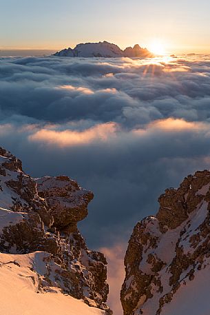 The sun sets behind the Marmolada peak over a sea of clouds, Cortina d'Ampezzo, dolomites, Veneto, Italy, Europe