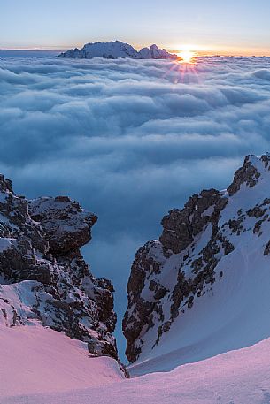 The sun sets behind the Marmolada peak over a sea of clouds, Cortina d'Ampezzo, dolomites, Veneto, Italy, Europe