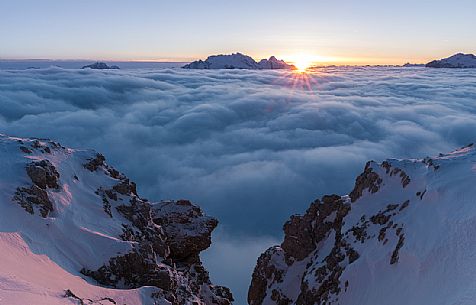 The sun sets behind the Marmolada peak over a sea of clouds, Cortina d'Ampezzo, dolomites, Veneto, Italy, Europe The sun sets behind the Marmolada peak over a sea of clouds, Cortina d'Ampezzo, dolomites, Veneto, Italy, Europe