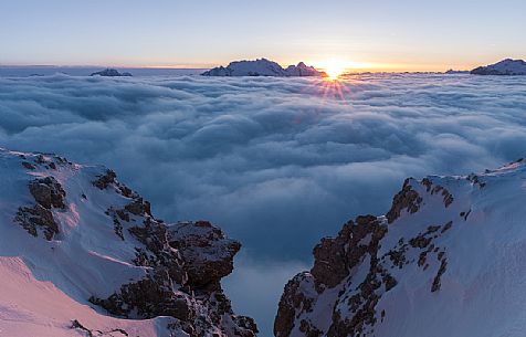 The sun sets behind the Marmolada peak over a sea of clouds, Cortina d'Ampezzo, dolomites, Veneto, Italy, Europe