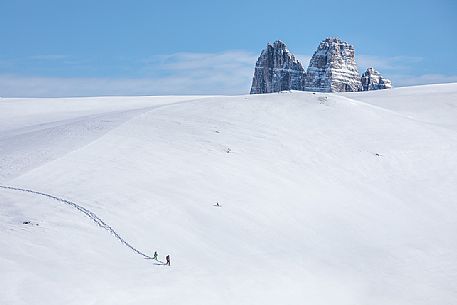 Trekkers with snowshoes descend from Mount Specie, in the background the Tre Cime di Lavaredo peak, Prato Piazza, Braies, Trentino Alto Adige, Italy, Europe Trekkers with snowshoes descend from Mount Specie, in the background the Tre Cime di Lavaredo peak, Prato Piazza, Braies, Trentino Alto Adige, Italy, Europe