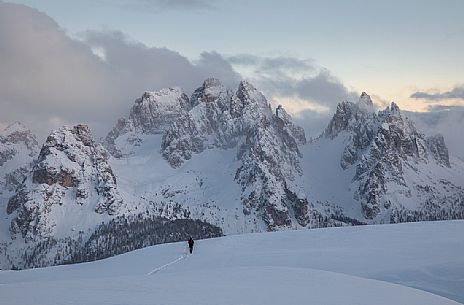 Hiker on the path to Monte Piana, in the background the clouds envelop the peaks of Cadini di Misurina, dolomites, Auronzo di Cadore, Veneto, Italy, Europe