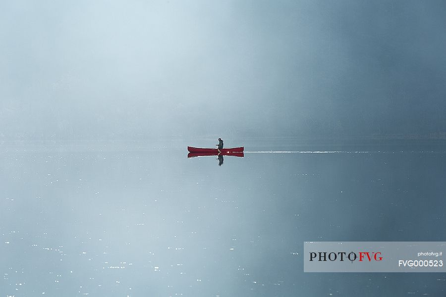 Rowing boat on the lake in the morning fog