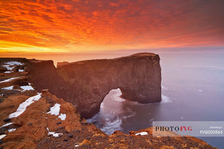 A very colourful sunrise makes the sky inflamed, on the coast nearby Vik.