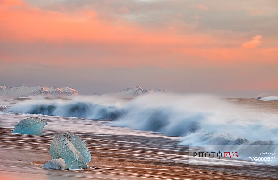 Ice, snow, pinky shades of the sunrise and the sea waves are the wintry ingredients of the volcanic beach of Jokulsarlon