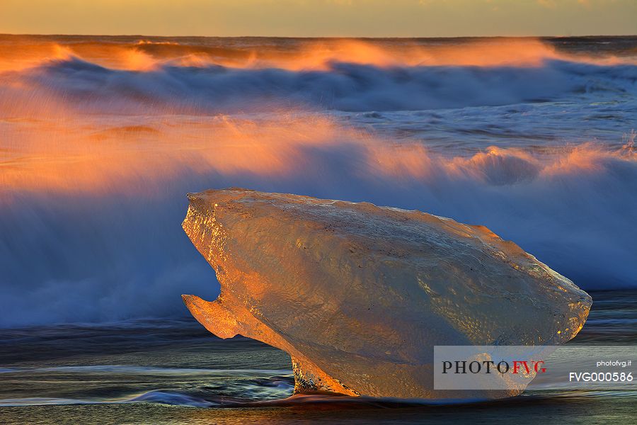 A fragment of ice stranded on the volcanic beach of Jokulsarlon clearly shows the strong contrast of the icelandic nature