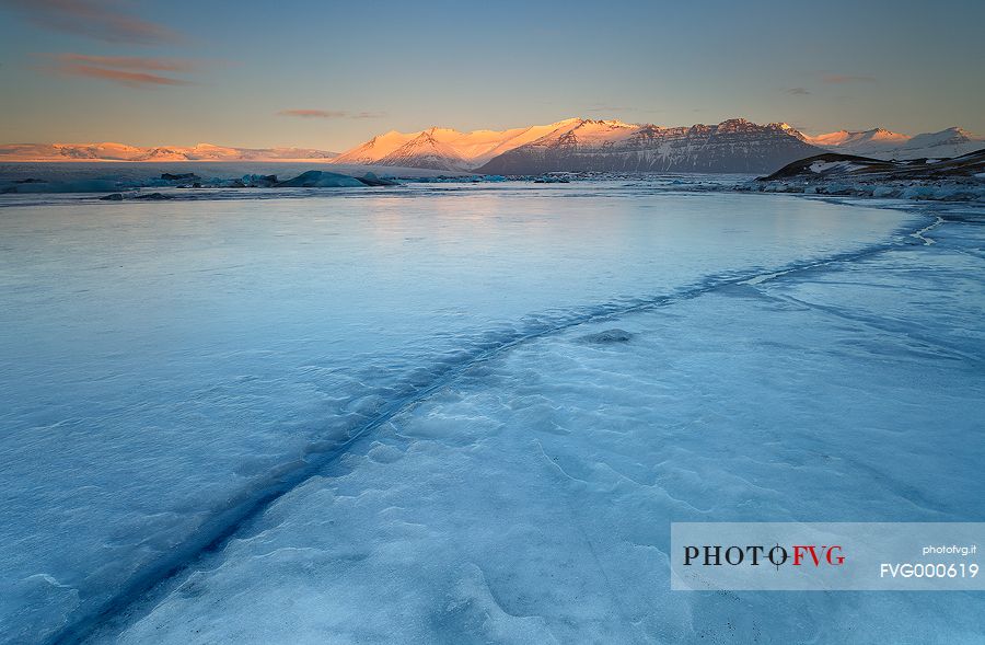 A frozen sunrise at Kirkjufell, the pyramidal mountain in the West of Iceland.