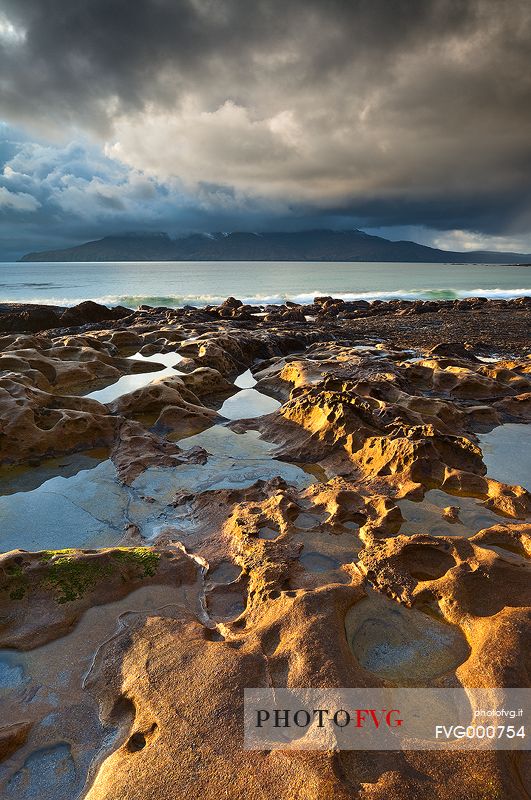 A beautiful transient light kisses the beach during a grey day