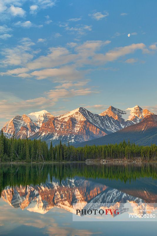 Moon is reflected at Herbert Lake during a colorful sunrise