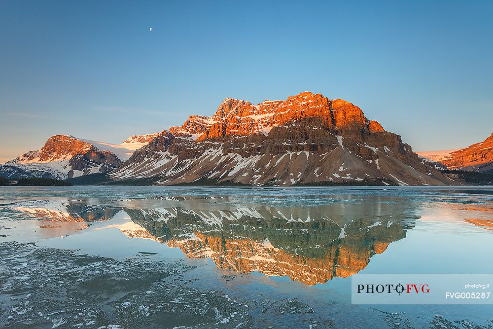 The moon above Bow lake at sunrise