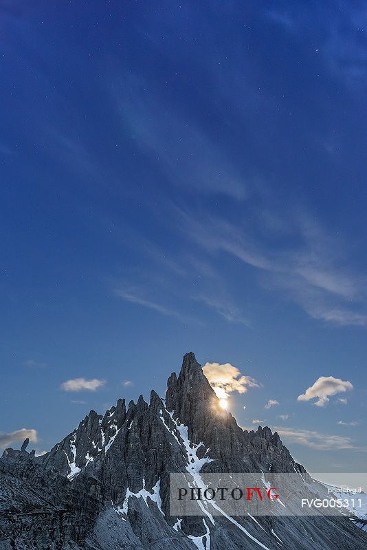 A night view of Mount Paterno with the moon setting just behind the mountains