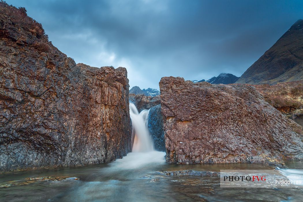 One of the beautiful waterfalls at fairy pools is illuminated by the last light in the afternoon, United Kingdom, UK, Scotland, Inner Hebrides , Isle of Skye 