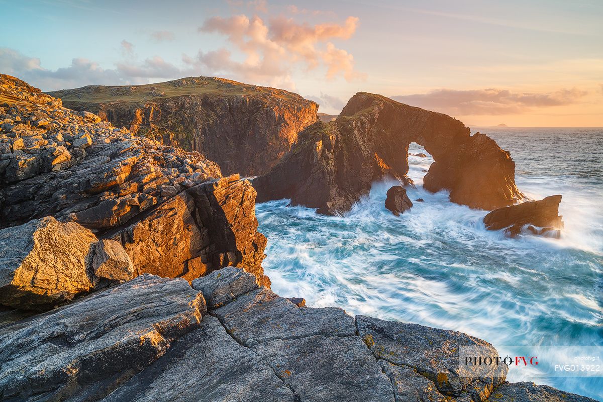 A beautiful arch in the sea illuminated by the last light in the evening