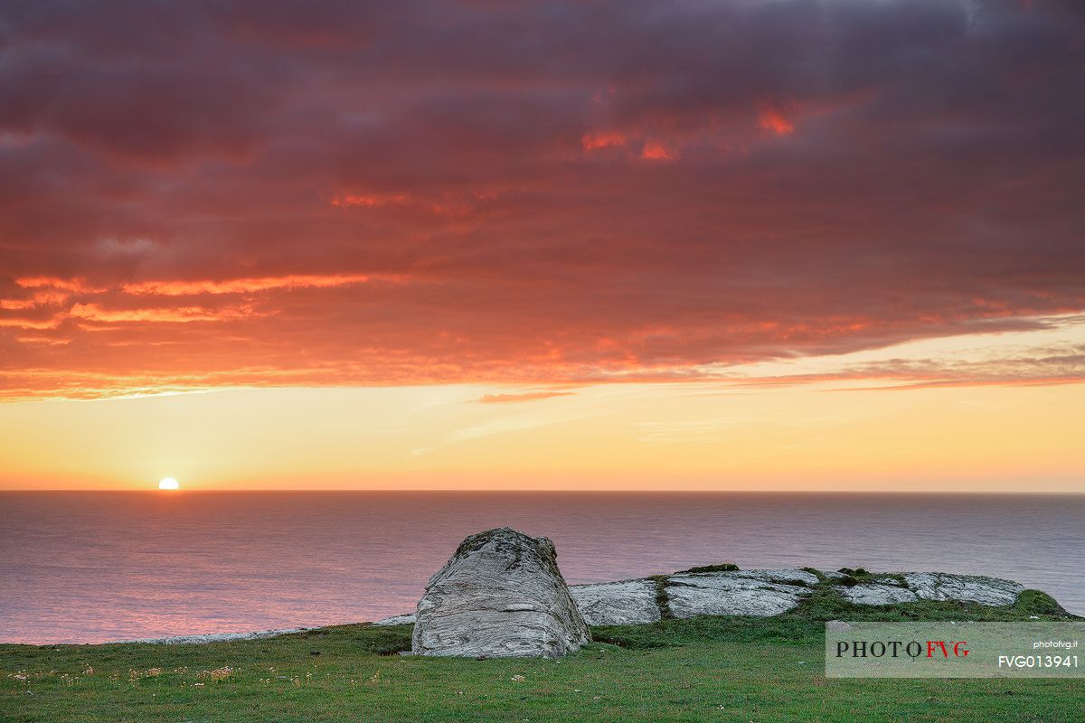 A set of stones admiring the sun while is setting down the horizon