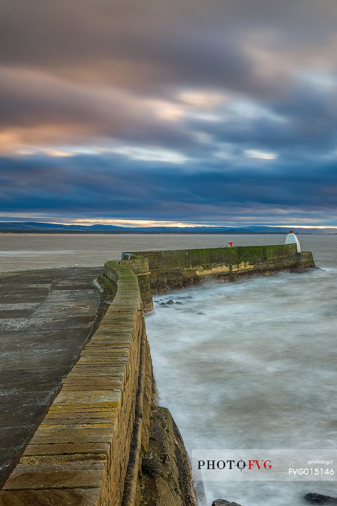 The wind and waves at Burghead Harbor during the sunset
