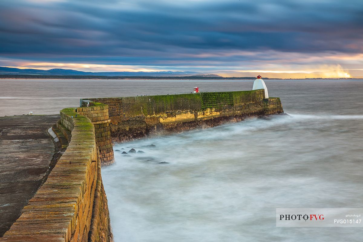 The wind and waves at Burghead Harbor during the sunset