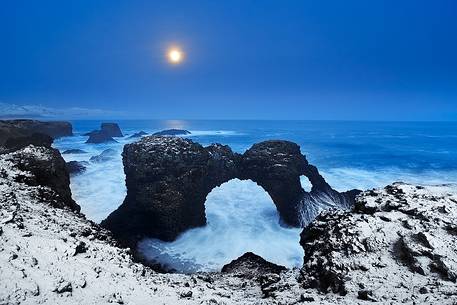 The full moon, the snow freshly fallen on the coast and the blue light after the sunset make this Arnarstapi landscape unique.