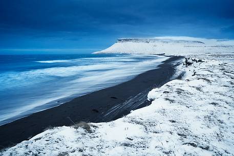 The snow freshly fallen and the gloomy sky on the Icelandic coasts during the month of January.