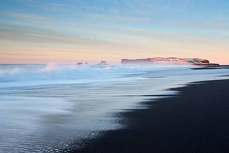 The volcanic beach at Vik gets enlightened by a winter sunrise.