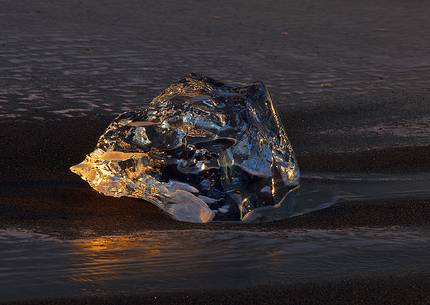 A fragment of ice stranded on the volcanic beach of Jokulsarlon clearly shows the strong contrast of the icelandic nature