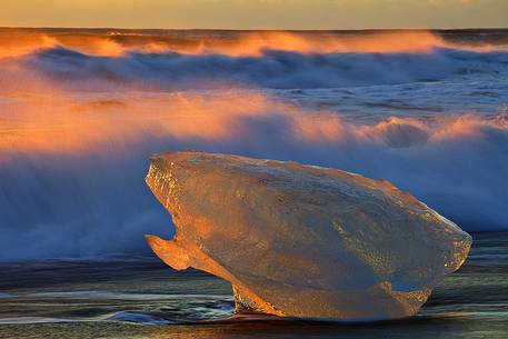 A fragment of ice stranded on the volcanic beach of Jokulsarlon clearly shows the strong contrast of the icelandic nature A fragment of ice stranded on the volcanic beach of Jokulsarlon clearly shows the strong contrast of the icelandic nature