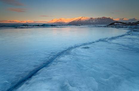 A frozen sunrise at Kirkjufell, the pyramidal mountain in the West of Iceland.