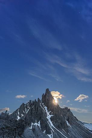 A night view of Mount Paterno with the moon setting just behind the mountains