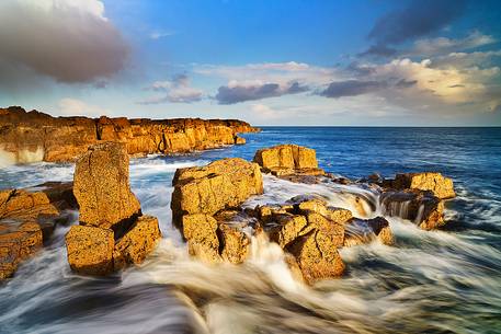 Contrast between the yellow rocks and the blue water at Staffin Bay