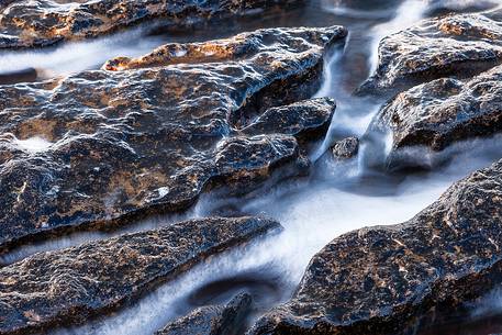 The sea water going through the grooves on the rock