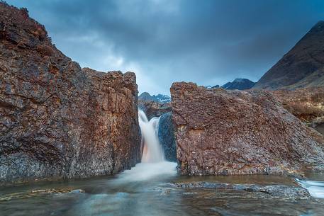 One of the beautiful waterfalls at fairy pools is illuminated by the last light in the afternoon, United Kingdom, UK, Scotland, Inner Hebrides , Isle of Skye 